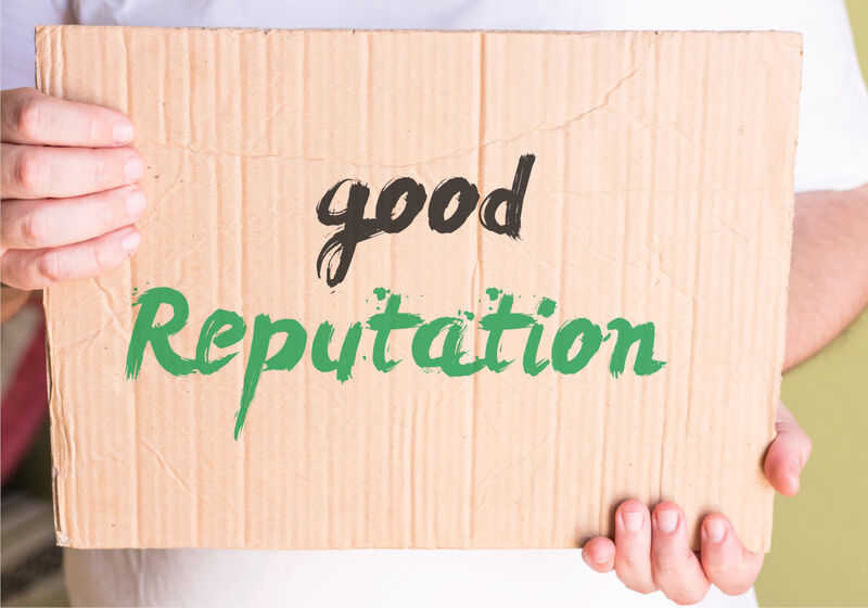 Photo of a cardboard sign being delivered with reputation written on it