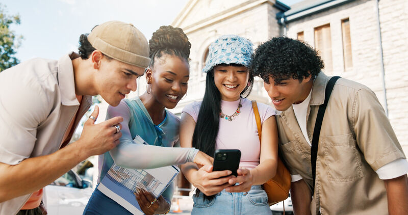 Student, friends and phone in college with social media update, scholar website or group email chat for education. People, smile and reading outdoor at university with tech, mobile app or email for online course