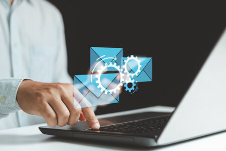 Graphic showing email automation over a laptop