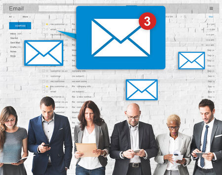 A group of people using computers and paper with email icons