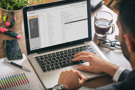 A man viewing emails on a laptop