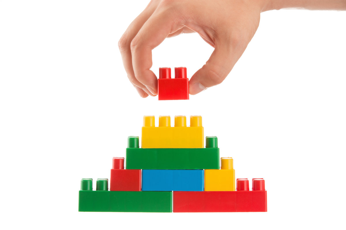 An image showing a wall being built out of toy blocks