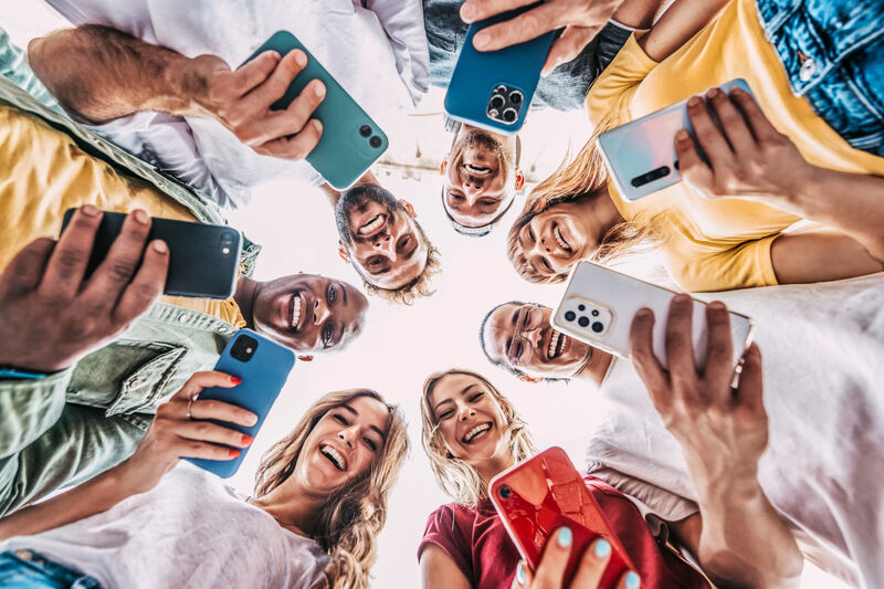 Photo of a group of young people looking at their smartphones